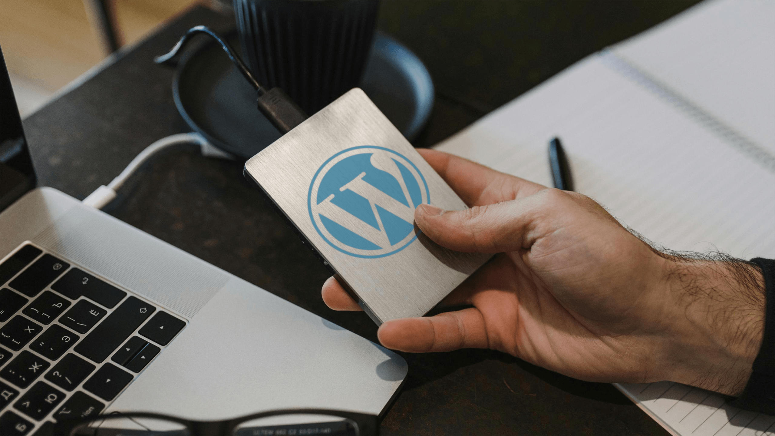 Man holding a hard drive with a WordPress logo